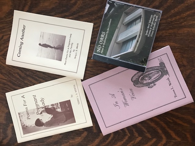 Three poetry chapbooks and the No Oars CD on a wooden surface: Poems For A Pregnant Lady, In A Woman's Voice, More Poems For A Pregnant Lady, and the No Oars jewel case.